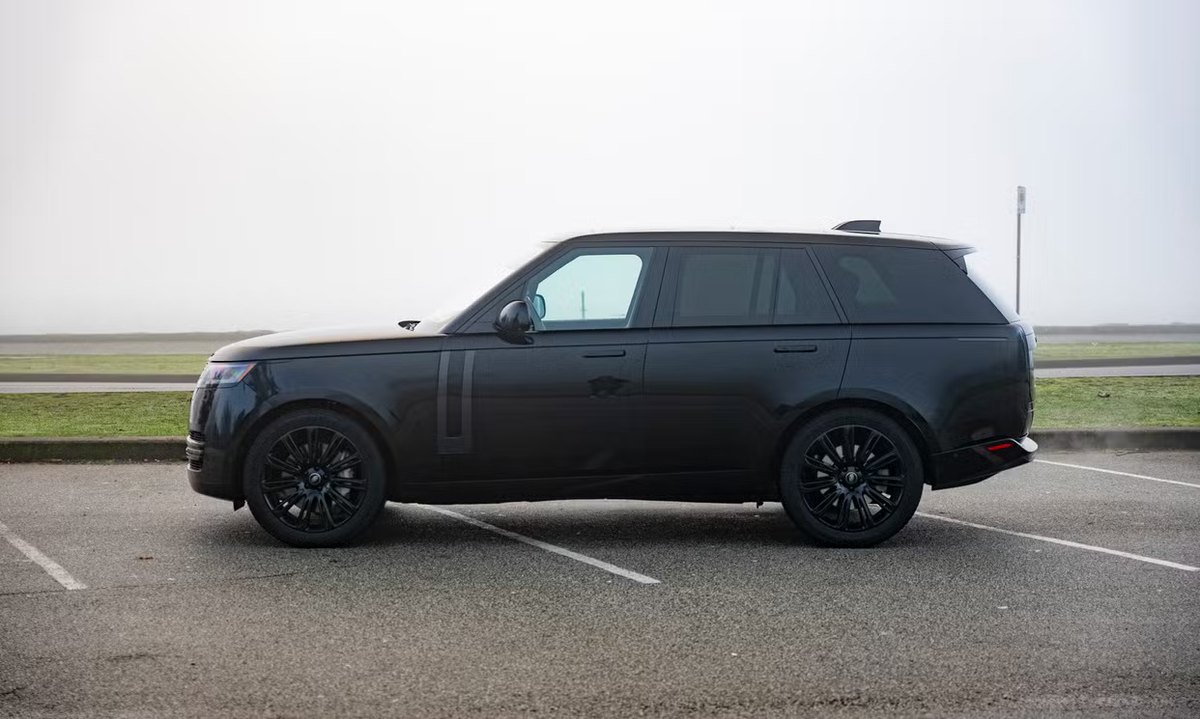 Black 2023 full-size Range Rover, side profile in fog